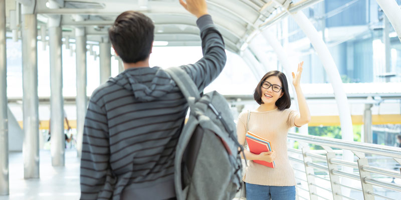 University students waving to one another